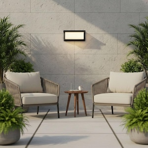 Pode incluir: Cena de pátio ao ar livre com duas poltronas, uma pequena mesa lateral de madeira e plantas em vasos. As cadeiras têm almofadas bege e estruturas em estilo corda. Uma luminária retangular é montada na parede texturizada.