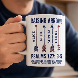 Op de afbeelding: Witte keramische mok met de tekst "RAISING ARROWS" en de namen "ALICE", "ALEX", "SOPHIA" en "HENRY" verticaal afgedrukt met pijldessins. De mok bevat ook de tekst "PSALMS 127: 3-5".