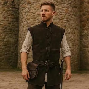 May include: A person wearing a dark brown leather vest with a matching belt and pouch. The vest has decorative buckles and is worn over a light-coloured long-sleeved shirt. A sword is visible at the person's side. The background features a stone wall and a castle entrance.