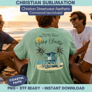 Op de afbeelding: Een lichtgroen t-shirt met de tekst "Stay Salty" en een strandscène, inclusief een strandwachttoren en palmbomen. De tekst "You are the salt of the earth" staat boven de hoofdtekst. Het shirt heeft ook de tekst "Matthew 5:13".