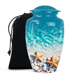 Pode incluir: Urna funerária turquesa com uma cena de praia com estrelas do mar e conchas. A urna tem um acabamento brilhante e é acompanhada por um saco de veludo preto com fecho de cordão. O design evoca um tema costeiro sereno.