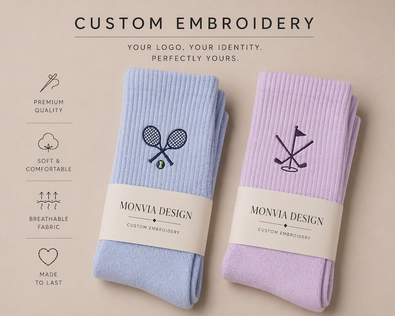 Puede incluir: Dos pares de calcetines acanalados en azul claro y lavanda, cada uno con bordado personalizado. El par azul muestra raquetas de tenis cruzadas y una pelota, el par lavanda palos de golf cruzados y una bandera. Ambos tienen etiquetas Monvia Design.