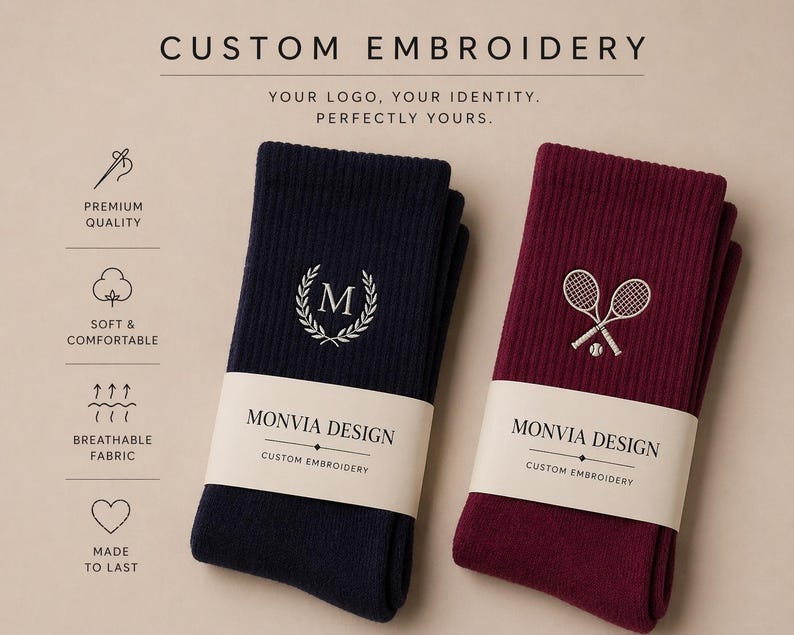 Puede incluir: Dos pares de calcetines acanalados, uno azul marino y otro burdeos, envueltos en una banda de papel con la etiqueta MONVIA DESIGN CUSTOM EMBROIDERY. El calcet&iacute;n azul marino tiene una letra M bordada en blanco dentro de una corona de laurel, mientras que el burdeos muestra dos raquetas de tenis cruzadas y una pelota. El texto superior dice CUSTOM EMBROIDERY, YOUR LOGO, YOUR IDENTITY, PERFECTLY YOURS, con iconos de calidad premium, suavidad, tejido transpirable y durabilidad.