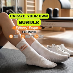 Pode incluir: Um par de meias brancas de cano médio com pontos antiderrapantes na sola e o texto "Pilates Princess" em letras cor de laranja. A imagem inclui os textos: "CREATE YOUR OWN BUNDLE", "Different Designs", "BULK SAVINGS", "BUNDLE & SAVE", "MIX & MATCH DESIGNS" e "STOCK UP & SAVE".