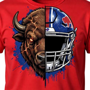 May include: Red t-shirt featuring a split design: a bison head on the left and a blue football helmet on the right. The bison is brown with glowing orange eyes. The helmet has a red bison logo and white stripes.