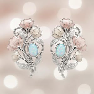 Könnte beinhalten: Ein Paar silberfarbene Blumenohrringe. Jeder Ohrring hat einen ovalen Opalstein in der Mitte, umgeben von stilisierten rosa und weißen Blumen. Das Design umfasst zarte Blätter und wirbelnde Akzente.