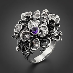 May include: A silver-toned ring featuring a cluster of orchid flowers. The ring has detailed floral designs with a central purple gemstone. The ring's band is smooth and polished, contrasting with the textured flowers.