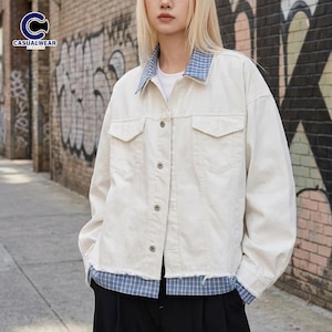 May include: Off-white denim jacket with a blue plaid collar and hem. The jacket has two chest pockets and a button-up front. The Casualwear logo is in the upper left corner.