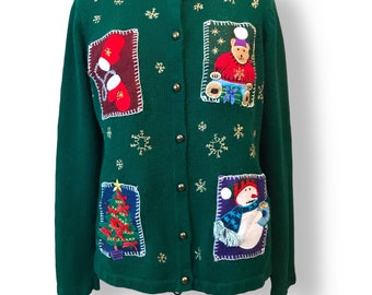 May include: Green Christmas sweater with a snowman, a Christmas tree, a teddy bear, and a stocking. The sweater has a button-up front and is decorated with gold snowflakes.
