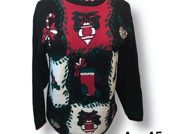 May include: Black Christmas sweater with a patchwork design featuring candy canes, ornaments, and stockings. The sweater has a green, red, and white color scheme.