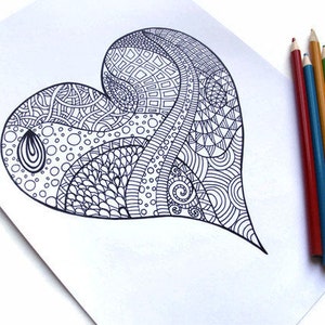May include: A detailed black and white heart-shaped drawing with intricate patterns, including geometric shapes, swirls, and dots. Colored pencils in red, blue, yellow, and green are arranged beside the drawing on a white surface.