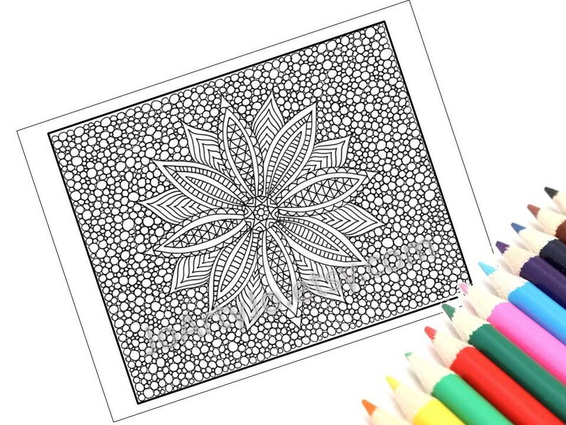 May include: Black and white mandala coloring page with a detailed floral design and a background of small circles. A set of colored pencils in various colors are in the lower right corner, ready for use.