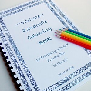 Peut inclure: Un livre de coloriage &agrave; spirales intitul&eacute; "Intricate Zendoodle Colouring Book" avec une bordure bleue &agrave; motifs. Six crayons de couleur, rouge, orange, jaune, vert, bleu et violet, sont dispos&eacute;s sur la page. Le livre contient 12 Zendoodles &agrave; colorier.
