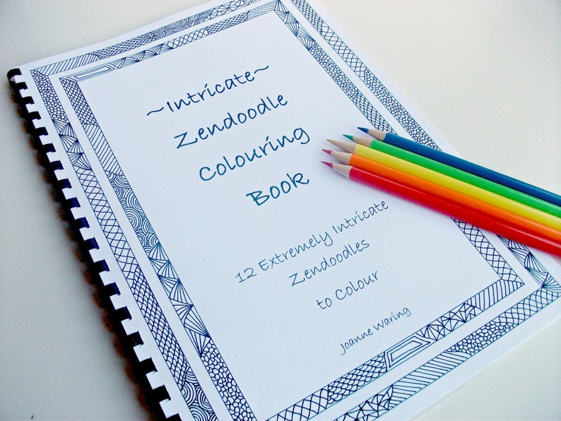 Peut inclure: Un livre de coloriage &agrave; spirales intitul&eacute; "Intricate Zendoodle Colouring Book" avec une bordure bleue &agrave; motifs. Six crayons de couleur, rouge, orange, jaune, vert, bleu et violet, sont dispos&eacute;s sur la page. Le livre contient 12 Zendoodles &agrave; colorier.