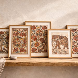 Könnte beinhalten: Fünf gerahmte Kunstdrucke mit aufwendigen Blumen- und Tiermotiven in warmen Rot-, Orange- und Beigetönen. Die Drucke werden auf einem Holzregal mit einer Vase mit getrockneten Pflanzen und einem dekorativen Stein ausgestellt.