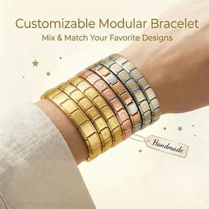 Puede incluir: Se muestran varias pulseras modulares en tonos dorados, oro rosa y plateado. Las pulseras presentan diferentes diseños, como corazones, estrellas y eslabones rectangulares. Se incluye el texto "Customizable Modular Bracelet" y "Mix & Match Your Favorite Designs."