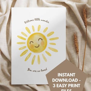 Puede incluir: Tarjeta blanca con una ilustración en acuarela de un sol amarillo sonriente. Los textos "Welcome little wonder" y "You are so loved" están escritos encima y debajo del sol. Una forma geométrica marrón con el texto "INSTANT DOWNLOAD - 3 EASY PRINT FILES" está a la derecha.