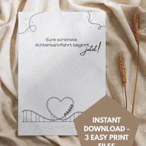 May include: A white rectangular card featuring the German text Eure schönste Achterbahnfahrt beginnt jetzt! with a black line drawing of a roller coaster forming a heart shape, small heart outlines, and a brown pentagonal overlay with white text.
