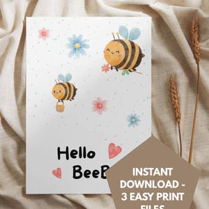 Op de afbeelding: Een witte kaart met aquarel illustraties van bijen, bloemen en harten. De tekst "Hello Bee" is in zwarte letters weergegeven. De kaart heeft een lichtbeige achtergrond met een bruine geometrische vorm met tekst.