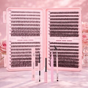 Könnte beinhalten: Ein rosa Wimpern-Set mit zwei offenen Etuis, gefüllt mit einzelnen und Cluster-Wimpern. Das Set enthält eine Tube Bond & Seal, Applikatoren und eine Wimpernbürste. Das Wort "Eyelashes" ist auf dem Etui aufgedruckt.