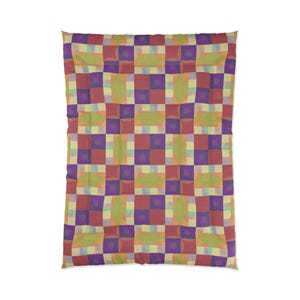 May include: A comforter with a geometric pattern in shades of red, purple, green, and yellow. The design features a grid of squares and oblong shapes, creating a patchwork effect. The comforter is a square shape.