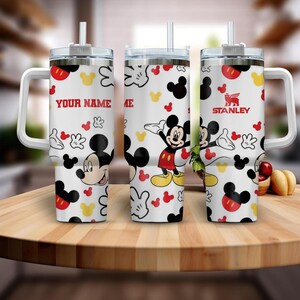 A set of three personalized tumblers featuring the character Mickey Mouse. The tumblers have a Mickey Mouse design and the text "YOUR NAME" printed on them.