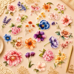 Könnte beinhalten: Eine Sammlung verschiedener Blumenaufkleber mit diversen Blüten im Aquarellstil, darunter Rosen, Hortensien, Tulpen und Lilien in Rosa-, Lila-, Blau-, Orange- und Gelbtönen, angeordnet auf einer hellbeigen Oberfläche neben einem goldenen Stift.