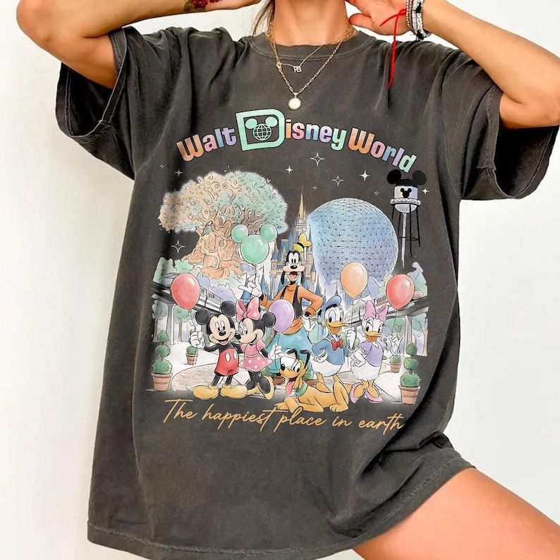 May include: Dark gray t-shirt featuring a colorful graphic of Disney characters, including Mickey and Minnie Mouse, Goofy, Donald and Daisy Duck, and Pluto. The shirt has the text "Walt Disney World" and "The happiest place on earth".
