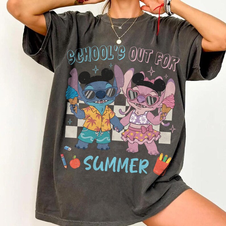 May include: Dark gray t-shirt featuring a cartoon illustration of two characters holding ice cream cones. The text "SCHOOL'S OUT FOR SUMMER" is printed above the characters in blue and pink. The characters are wearing sunglasses and summer attire.