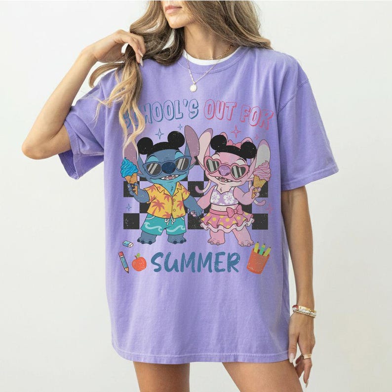 May include: A lilac-colored t-shirt featuring a cartoon illustration of Stitch and Angel holding ice cream cones. The text "SCHOOL'S OUT FOR SUMMER" is printed above the characters. The shirt has a relaxed fit.
