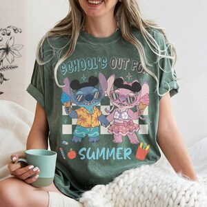 May include: Green t-shirt with the text "SCHOOL'S OUT FOR SUMMER". The shirt features a cartoon illustration of two characters holding ice cream cones. One character is blue, and the other is pink, both wearing sunglasses.