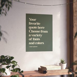 Może przedstawiać: Prostokątny plakat ścienny z ciemnooliwkowym tłem i kremowym tekstem o treści: Your favorite quote here Choose from a variety of fonts and colors - author (optional). Plakat jest umieszczony na białej ścianie.