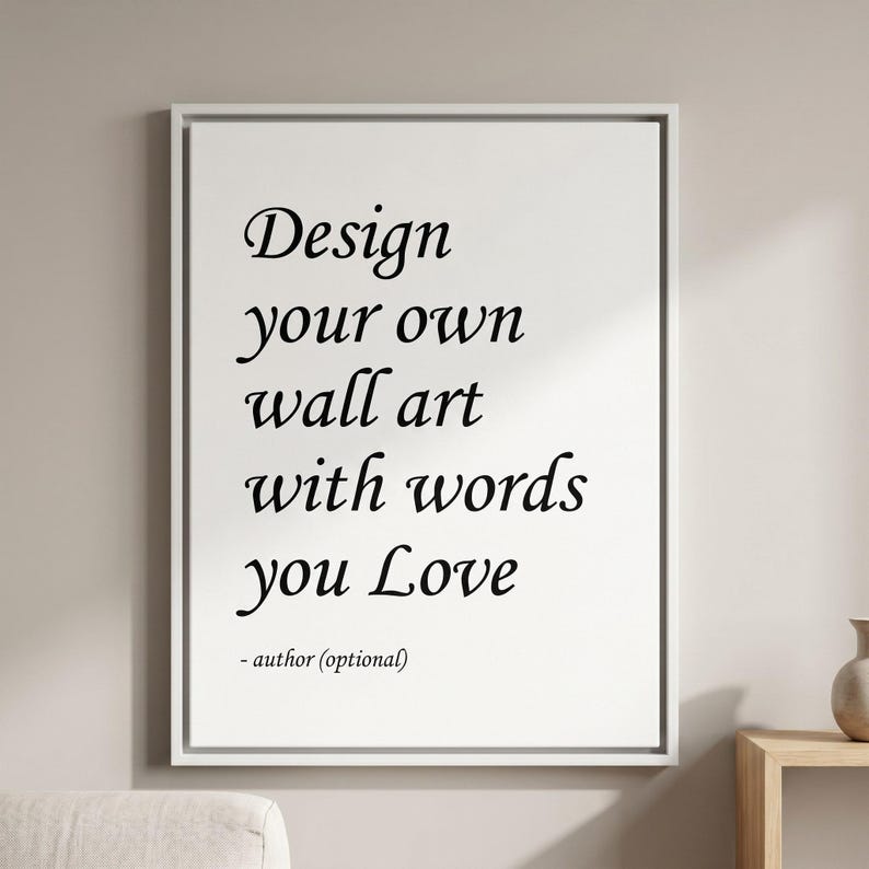 Może przedstawiać: Prostokątny biały wydruk ścienny w cienkiej białej ramie z czarnym tekstem: Design your own wall art with words you Love - author (optional). Typografia łączy style szeryfowe z kursywą przypominającą pismo odręczne.