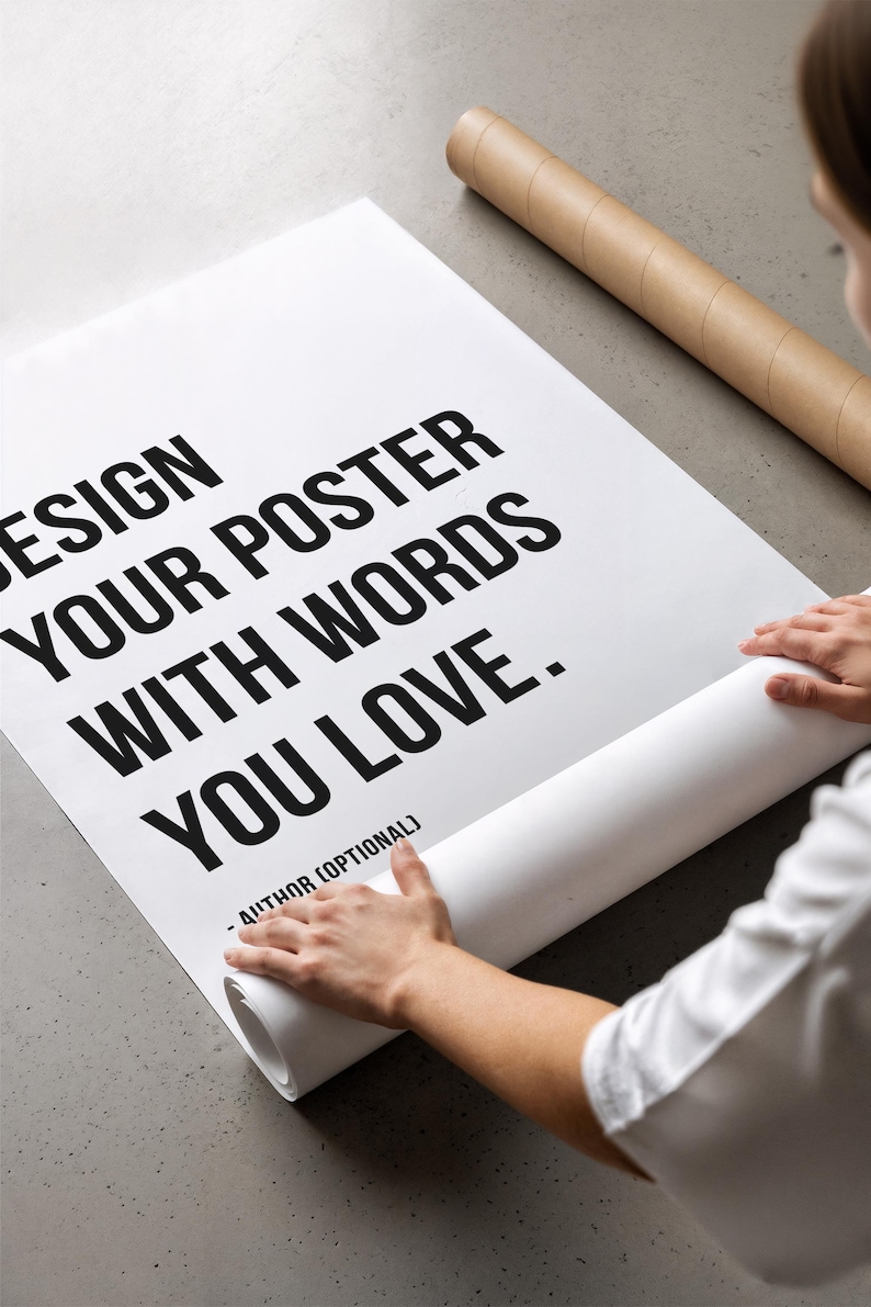 Może przedstawiać: Duży biały prostokątny plakat z pogrubionym czarnym tekstem o treści: DESIGN YOUR POSTER WITH WORDS YOU LOVE. - AUTHOR (OPTIONAL). Plakat jest częściowo rozwinięty z brązowej tekturowej tuby na płaskiej powierzchni.