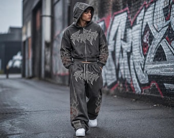 Conjunto urbano de color carbón con efecto desteñido ácido, sudadera gótica con capucha y pantalones deportivos de pierna ancha.
