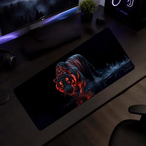 May include: A rectangular desk mat featuring a dark, high-contrast graphic of a tiger prowling through water. The tiger is rendered in deep black with glowing red and orange highlights along its fur and eyes, creating a striking visual effect.