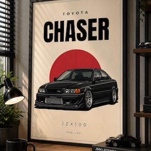 Puede incluir: Póster enmarcado con una ilustración de un coche Toyota Chaser negro. El póster tiene el texto "TOYOTA CHASER" encima del coche y "JZX100 1996-2001" debajo. Un círculo rojo está detrás del coche. Una taza negra con "/TRD" está en el escritorio.