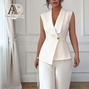 以下が含まれることがあります： 白のノースリーブブレザーと、お揃いのワイドレッグパンツ。 ブレザーは、シングルゴールドボタン留めのラップスタイルデザインです。 フォーマルまたはビジネスウェアに適した、コーディネートされたセットです。