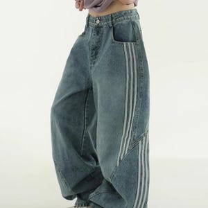 Baggy Wide Leg Jeans | Retro Oversized Pants | Spliced Denim Trousers | Alternative Y2K Grunge Streetwear
.
Women's oversized wide-leg denim pants with spliced striped detailing, baggy streetwear jeans in retro Y2K fashion style, perfect for alternative and casual outfits.