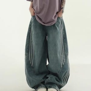 Baggy Wide Leg Jeans | Retro Oversized Pants | Spliced Denim Trousers | Alternative Y2K Grunge Streetwear
.
Women's oversized wide-leg denim pants with spliced striped detailing, baggy streetwear jeans in retro Y2K fashion style, perfect for alternative and casual outfits.