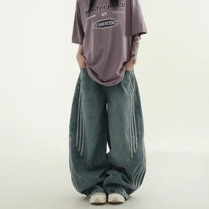 Baggy Wide Leg Jeans | Retro Oversized Pants | Spliced Denim Trousers | Alternative Y2K Grunge Streetwear
.
Women's oversized wide-leg denim pants with spliced striped detailing, baggy streetwear jeans in retro Y2K fashion style, perfect for alternative and casual outfits.
