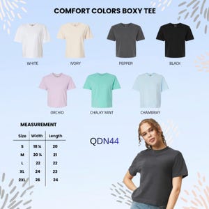 May include: A display of Comfort Colors boxy tees in various colors: white, ivory, pepper, black, orchid, chalky mint, and chambray. Measurements are provided for sizes S to 2XL. The model is wearing a pepper-colored tee.