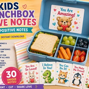 May include: A blue lunchbox with a sandwich, grapes, blueberries, carrots, and strawberries. Includes a water bottle and cards with positive messages like "You Are Amazing!" and "You Are So Loved!" The text reads "Kids Lunchbox Love Notes."