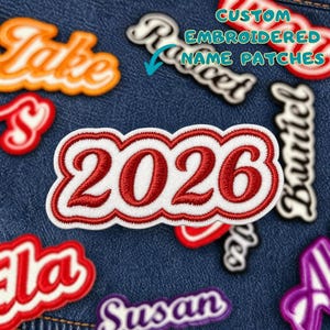 Może przedstawiać: Haftowane naszywki z imionami i numerami w różnych kolorach i czcionkach, w tym biało-czerwona naszywka z napisem "2026". Inne naszywki wyświetlają imiona takie jak "Jake" i "Susan". Widoczny jest również tekst "CUSTOM EMBROIDERED NAME PATCHES".
