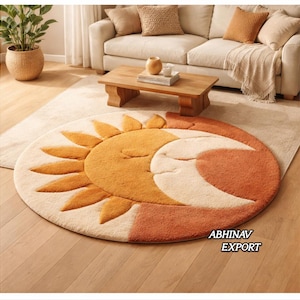 Könnte beinhalten: Ein runder Teppich mit einem Sonnen- und Monddesign in Orange, Creme und Weiß. Die Sonne hat ein lächelndes Gesicht und der Mond ist halbmondförmig. Der Teppich liegt auf einem Holzboden in einem Wohnzimmer.