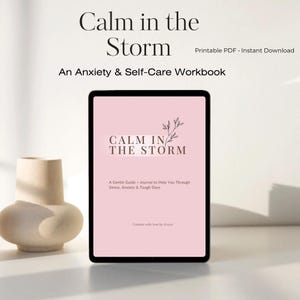 以下が含まれることがあります： デジタルタブレットには、「Calm in the Storm」というタイトルのセルフケアワークブックの表紙が表示されています。表紙は薄いピンク色で、タイトルは黒、花の模様です。ワークブックは、不安とセルフケアのガイドとして説明されています。