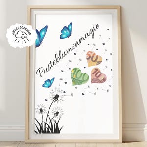 May include: A framed art print with a whimsical design. It features blue butterflies, dandelion silhouettes, and heart-shaped currency notes. The German text "Pusteblumenmagie" is written in cursive. The print is in a light wooden frame.