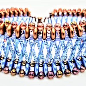 May include: A beaded bracelet with a woven design in shades of blue and copper. The bracelet has a layered look with different sized beads.