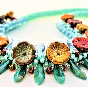 May include: A turquoise and brown beaded necklace with flower-shaped beads. The necklace has a cascading design with turquoise beads and flower-shaped beads in shades of brown, red, and orange.