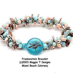 May include: A bracelet with a turquoise dragonfly clasp, featuring light blue, peach, and metallic beads. The text "Frankenstein Bracelet" and "Miami Beach Colorway" are visible. A stylish piece of jewellery.